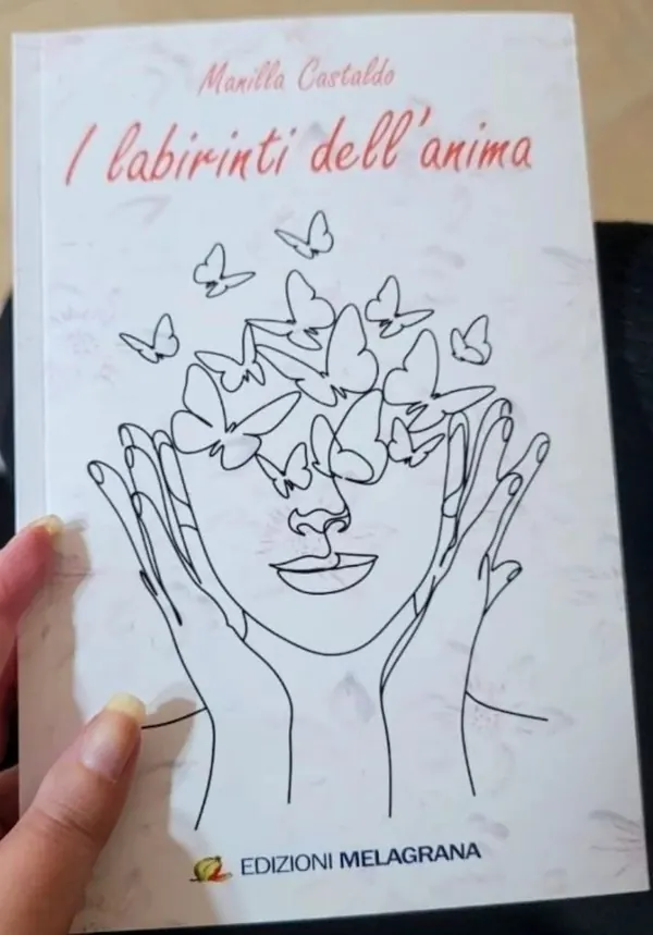 Copertina del libro «I labirinti dell'anima» di Manilla Castaldo, Edizioni Melagrana: un volto disegnato a linea tra le mani, con farfalle in volo
